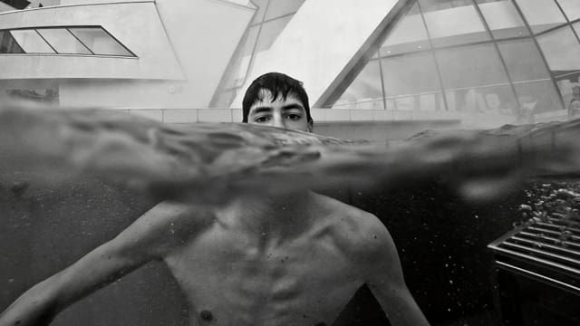 Schwarzweissaufnahme: Ein junger Mann in einem Schwimmbecken Schwarzweissaufnahme: Ein junger Mann in einem Schwimmbecken