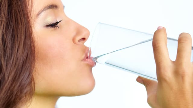 Frau trinkt Wasser aus einem Glas Frau trinkt Wasser aus einem Glas