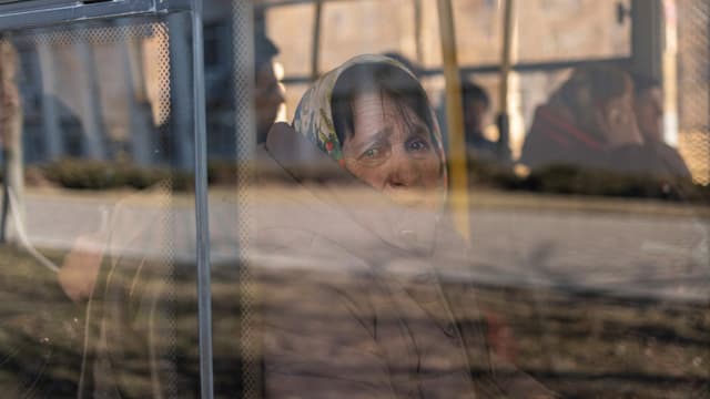 A woman waits on a bus to be evacuated from the city of Brovary near Kyiv. A woman waits on a bus to be evacuated from the city of Brovary near Kyiv.