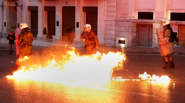 Detonierte Brandflaschen, die Polizei daneben. Detonierte Brandflaschen, die Polizei daneben.
