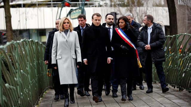 Macron und weitere Personen zu Fuss unterwegs. Macron und weitere Personen zu Fuss unterwegs.