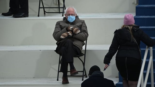 Bernie Sanders sitzt mit Atemschutzmaske und Handschuhen auf einem Klappstuhl Bernie Sanders sitzt mit Atemschutzmaske und Handschuhen auf einem Klappstuhl