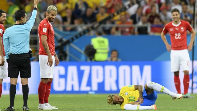 Behrami lächelt über den am Boden liegenden Neymar. Behrami lächelt über den am Boden liegenden Neymar.
