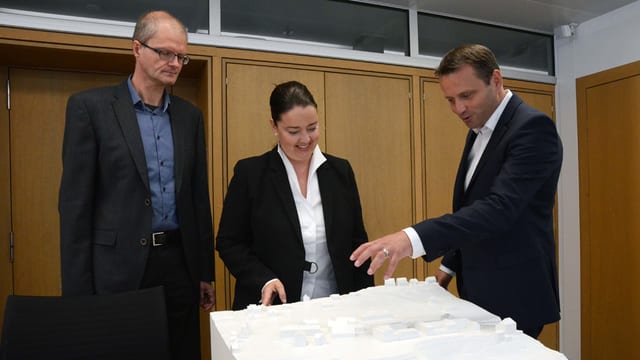 Drei Personen begutachten das Gipsmodell. Drei Personen begutachten das Gipsmodell.