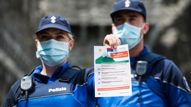 zwei Polizisten halten ein Infoblatt in die Kamera. zwei Polizisten halten ein Infoblatt in die Kamera.