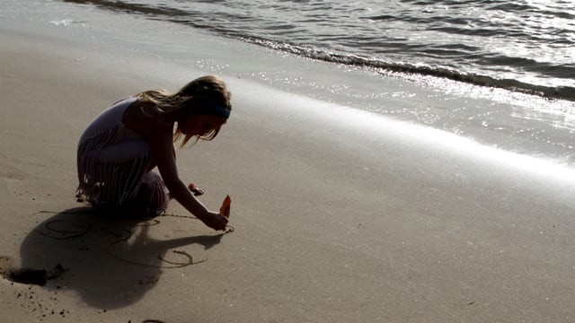 Ein Mädchen spielt am Strand (Symbolbild). Ein Mädchen spielt am Strand (Symbolbild).