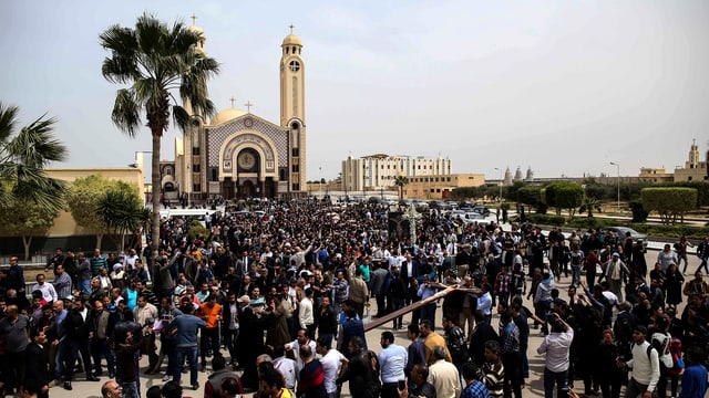Viele Menschen vor einer Kirche, zu sehen auch Palmen. Viele Menschen vor einer Kirche, zu sehen auch Palmen.