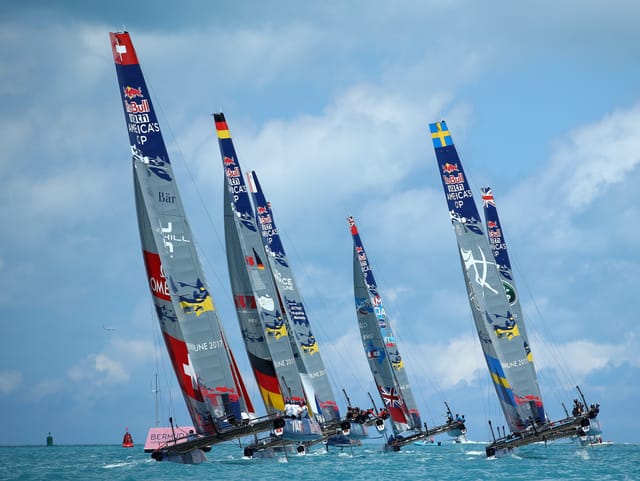 6 Boote fliegen übers Wasser in den blauen Horizont.