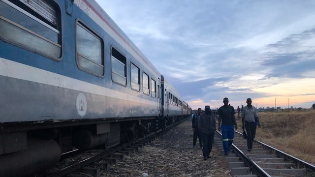 Die Passagiere gehen dem Wagen entlang zum Eingang. Die Passagiere gehen dem Wagen entlang zum Eingang.