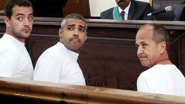 Baher Mohammed, Mohammed Fahmy und Peter Greste in weisser Gefängniskleidung vor Gericht in Kairo.