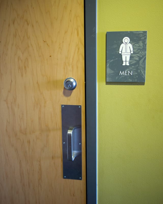 Das Schild mit der Aufschrift MEN zeigt einen warm angezogenen Mann. Das Schild mit der Aufschrift MEN zeigt einen warm angezogenen Mann.