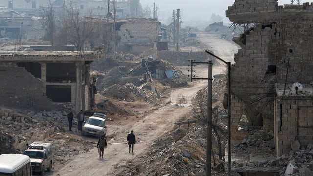 Zerbombte Stadt, einige Kämpfer in der Ferne auf einer Strasse. Zerbombte Stadt, einige Kämpfer in der Ferne auf einer Strasse.