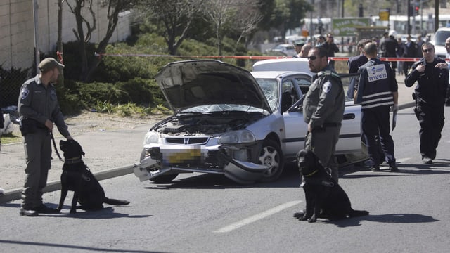 Sicherheitsleute bewachen das Auto, das in Jerusalem in eine Menschenmenge gefahren ist. Sicherheitsleute bewachen das Auto, das in Jerusalem in eine Menschenmenge gefahren ist.