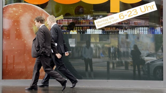 Personen gehen an einem Laden vorbei. Personen gehen an einem Laden vorbei.