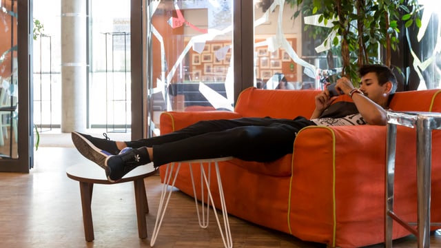 Ein Junge sitzt mit dem Handy auf einem Sofa. Ein Junge sitzt mit dem Handy auf einem Sofa.