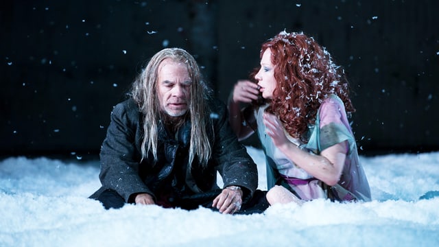 Eine Frau und ein Mann sitzen im Schnee. Eine Frau und ein Mann sitzen im Schnee.