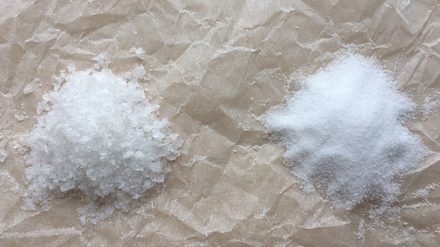 Zweo kleine Häufchen Salz :grobkörniges Maldon Salz und feinkörniges Tafelsalz.