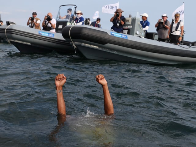 Tokyo 2020 Olympics - Sailing - Men's RS:X - Medal Race - Enoshima Yacht Harbour - Tokyo, Japan - July 31, 2021. Kiran Badloe of the Netherlands gets into the water to celebrate winning gold after the race