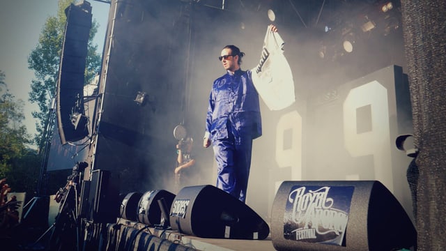 Eine Bühne mit einem in einem blauen Seidenpyjama gekleideten Rapper Eine Bühne mit einem in einem blauen Seidenpyjama gekleideten Rapper
