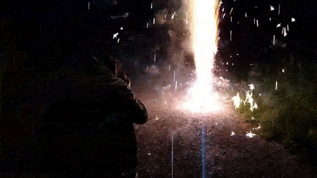 Ein Mann filmt einen Feuerwerks-Vulkan.