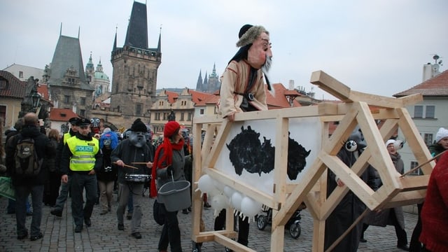 Der Umzug nach Vorbild der Basler Fasnacht auf der Prager Karlsbrücke im November 2012. Figuren mit Larven und Kostümen im selbstgebauten Wagen und Trommler. Am Rand stehen Zuschauer. Der Umzug nach Vorbild der Basler Fasnacht auf der Prager Karlsbrücke im November 2012. Figuren mit Larven und Kostümen im selbstgebauten Wagen und Trommler. Am Rand stehen Zuschauer.