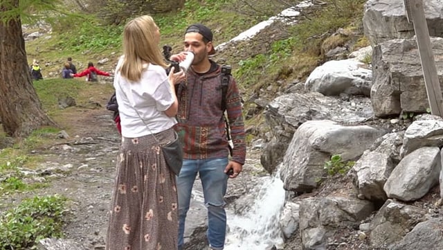 Influencer steht an einem Bächlein und trinkt Wasser. Influencer steht an einem Bächlein und trinkt Wasser.