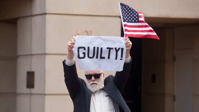 Mann mit «Guilty»-Plakat. Mann mit «Guilty»-Plakat.
