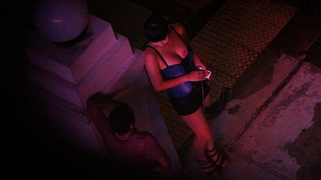 Leichtbekleidete Thailänderin in einer dunklen Strasse.