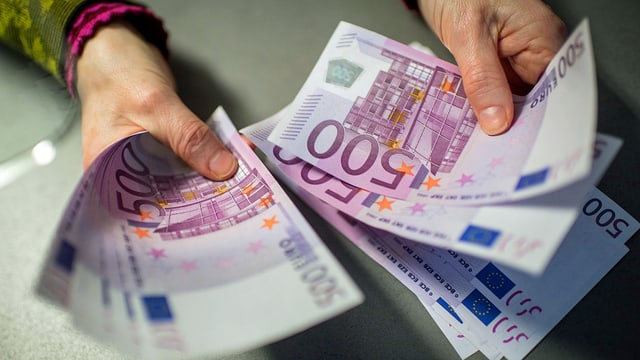 Frau hält 500-Euro-Noten Frau hält 500-Euro-Noten