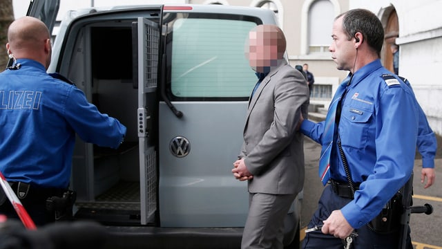 Polizisten führen verurteilten Mörder zu einem Kastenwagen. Polizisten führen verurteilten Mörder zu einem Kastenwagen.