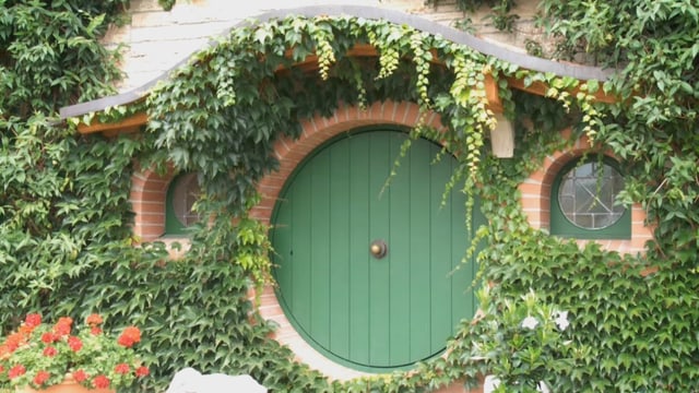 Das Hobbit-Museum mit seiner runden Tür und der efeubewachsenen Fassade Das Hobbit-Museum mit seiner runden Tür und der efeubewachsenen Fassade