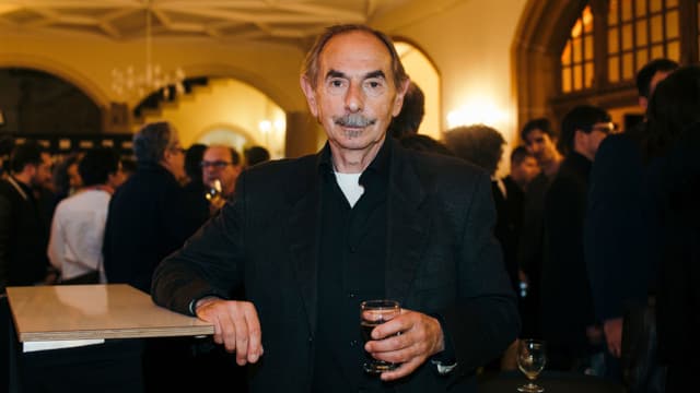 Ein mann an einem Stehtisch mit einem Glas in seiner Linken. Ein mann an einem Stehtisch mit einem Glas in seiner Linken.