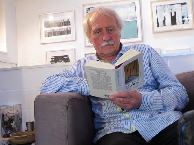 Ernst Wohlwend sitzt lesend in einem Sessel. Ernst Wohlwend sitzt lesend in einem Sessel.