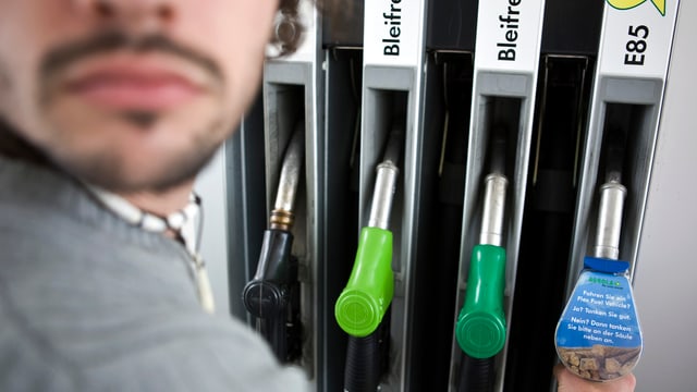 Unscharfe Person im Vordergrund, die sich an einer Tanksäule bedient. Unscharfe Person im Vordergrund, die sich an einer Tanksäule bedient.