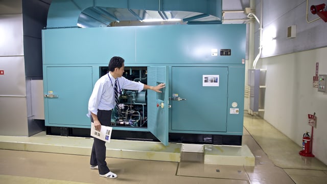 Nakashima-san öffnet die Luke zur Turbine des Generators. Nakashima-san öffnet die Luke zur Turbine des Generators.