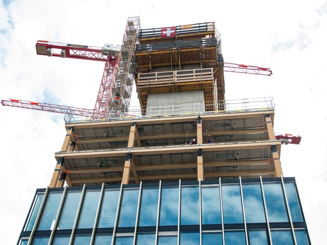 Hochhaus aus Holz auf grünem Glaskubus aufgesetzt, steile Aufnahme aus der Froschperspektive Hochhaus aus Holz auf grünem Glaskubus aufgesetzt, steile Aufnahme aus der Froschperspektive