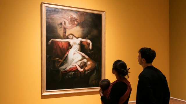 Ein Paar sieht sich ein Gemälde im Museum an Ein Paar sieht sich ein Gemälde im Museum an