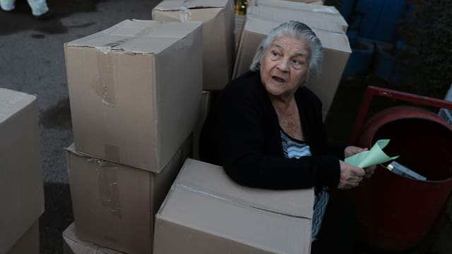 Eine Frau in Santiago sitzt zwischen Lebensmittelpaketen der Regierung. Eine Frau in Santiago sitzt zwischen Lebensmittelpaketen der Regierung.