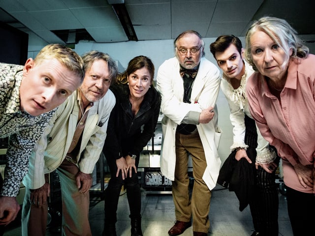 Menschen stehen in einem Kreis und schauen in die Kamera Menschen stehen in einem Kreis und schauen in die Kamera