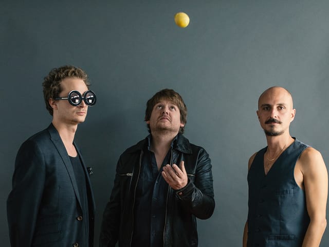 Die drei Jungs von der Band stehen nebeneinander. Die drei Jungs von der Band stehen nebeneinander.