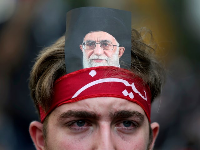 Hisbollah-Aktivist mit dem Abbild Chameneis. Hisbollah-Aktivist mit dem Abbild Chameneis.