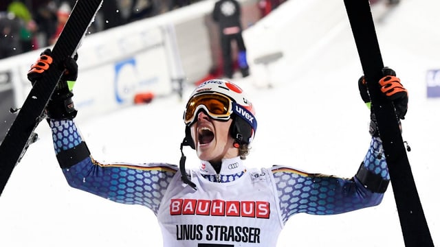Linus Strasser streckt vor Freude seine Skier in die Luft. Linus Strasser streckt vor Freude seine Skier in die Luft.