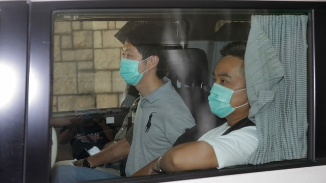 Zwei Hongkonger sitzen in einem Auto, sie tragen Hygienemasken. Zwei Hongkonger sitzen in einem Auto, sie tragen Hygienemasken.