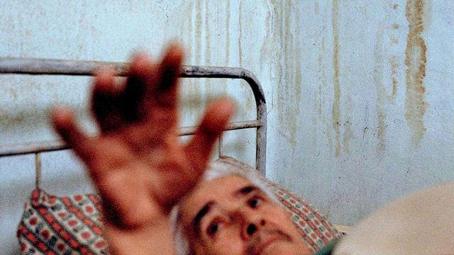 Mann liegt im Bett und streckt die Hand hoch. Mann liegt im Bett und streckt die Hand hoch.