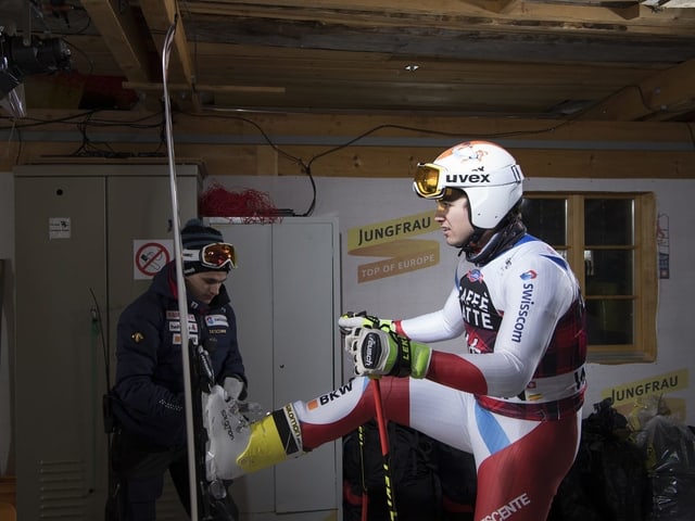 Urs Kryenbühl steht mit den Skiern vor dem Serviceman. Urs Kryenbühl steht mit den Skiern vor dem Serviceman.