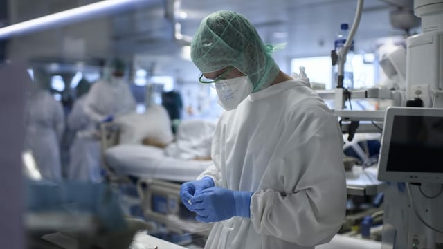 Pflegende in Schutzausrüstung auf einer Intensiv-Plegabteilung. Pflegende in Schutzausrüstung auf einer Intensiv-Plegabteilung.