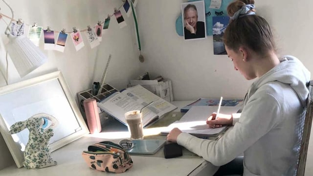 Eine junge Frau sitz an einem Schreibtisch. Eine junge Frau sitz an einem Schreibtisch.