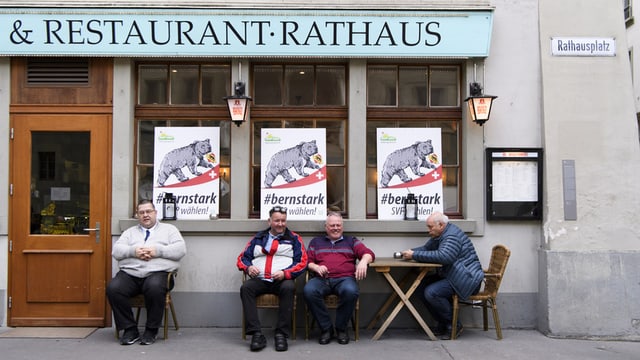 Vier Männer sitzen vor dem Restaurant Rathaus Vier Männer sitzen vor dem Restaurant Rathaus