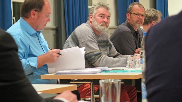 Blick auf Männer an einem Tisch im Ratssaal Blick auf Männer an einem Tisch im Ratssaal