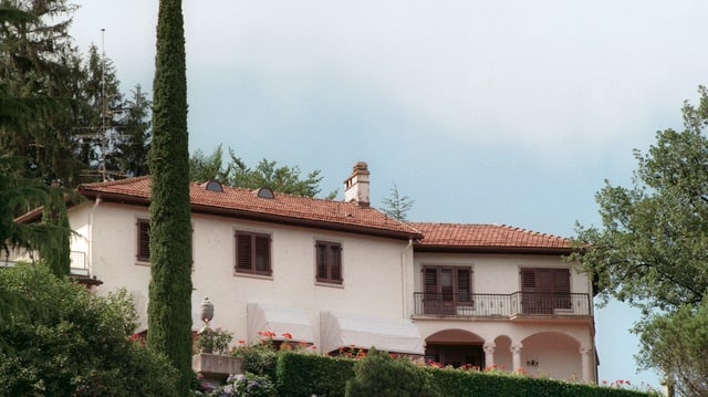 Ein beiges Haus mit einem gut gepflegten Garten um das Haus herum. Ein beiges Haus mit einem gut gepflegten Garten um das Haus herum.